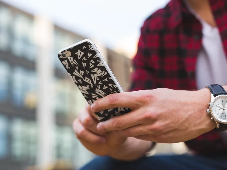 Homem com celular e relógio
