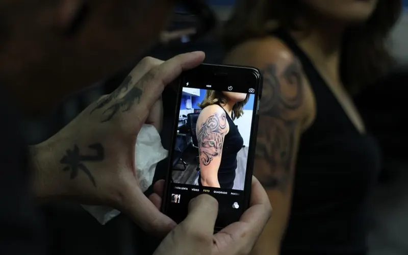 Jovem com celular e câmera
