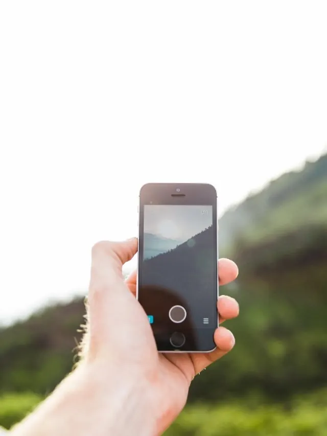 Mãos com celular e câmera