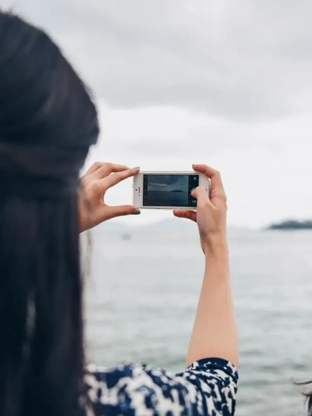 Mulher com celular e câmera