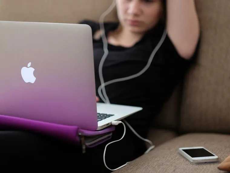 Mulher com celular e notebook