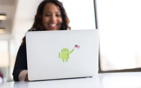 Mulher com celular e notebook no escritório