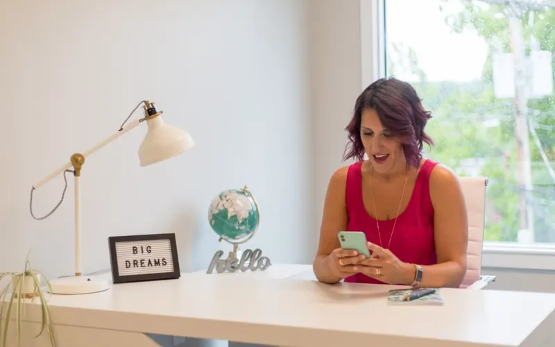 Mulher com celular no escritório