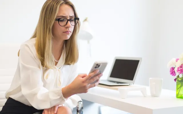 Mulher com celular no escritório