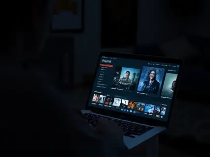 Notebook exibindo catálogo de filmes em ambiente escuro