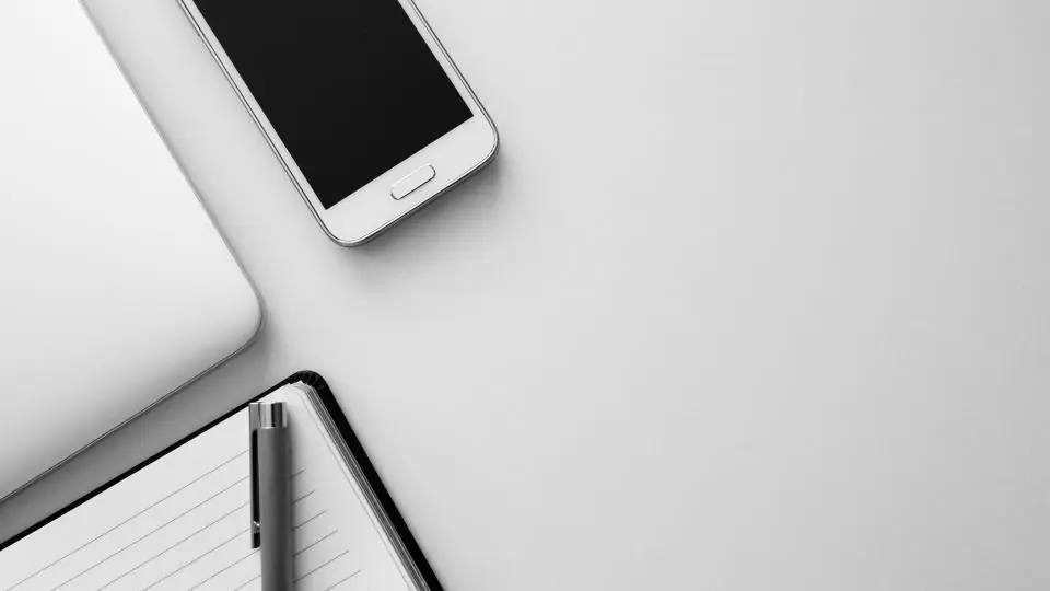 Smartphone sobre um caderno em mesa clara